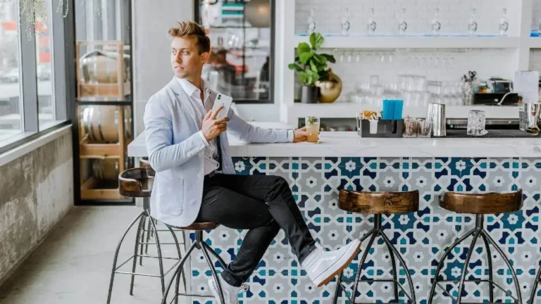 Typ mit Smartphone in Bar