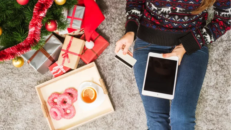 young woman holding credit card tablet christmas