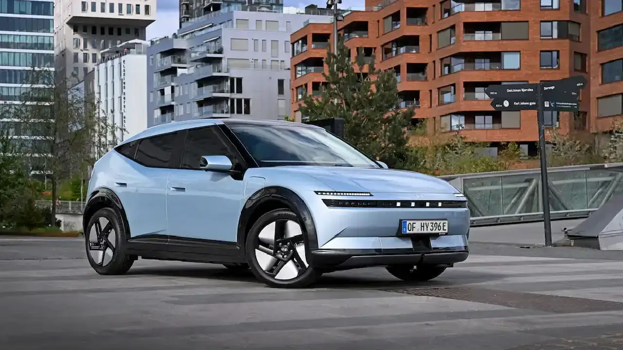 Seitenansicht des blauen Hyundai Ioniq 3 vor einer Häuserschlucht