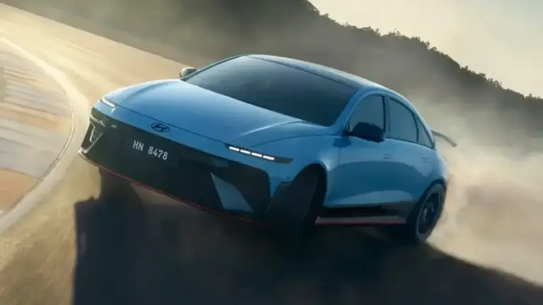 Der hellblaue Hyundai Ioniq 6 N im extremen Drift auf einer Rennstrecke. Das Elektro-Sportwagen-Modell wirbelt bei der Kurvenfahrt eine dichte weiße Rauchwolke auf