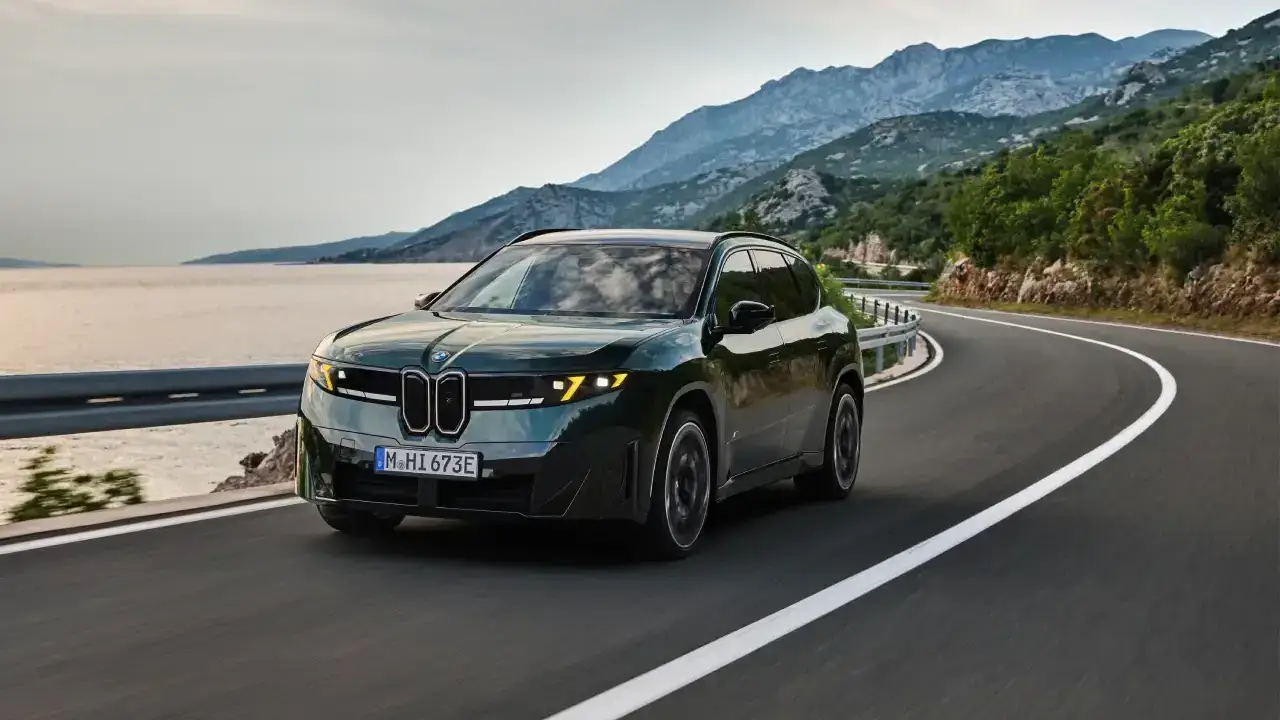 dynamische Frontansicht BMW iX3 M60 auf einer Landstraße am Meer